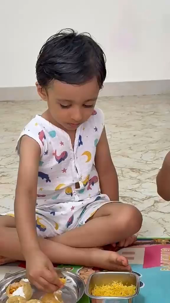 Child enjoying snack time at Vasishtha School