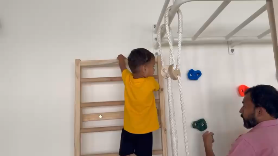 Child and parent at the climbing ladder at Vasishtha School